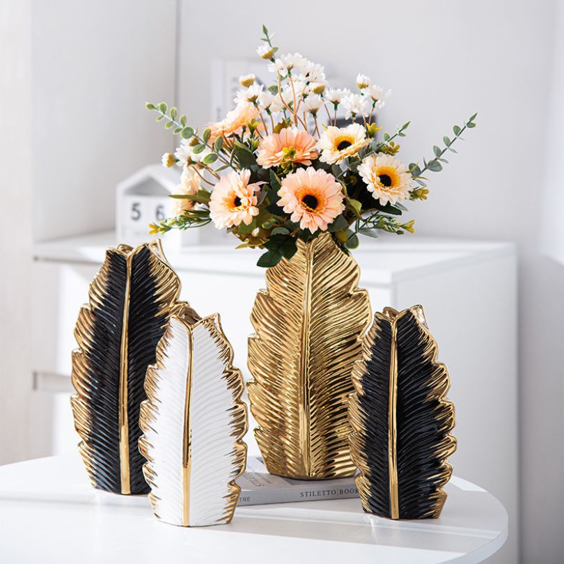 Elegant Nordic gold pleated leaf ceramic vase set displayed on a modern dining table.