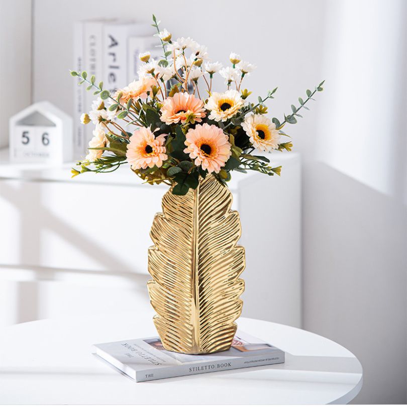 Elegant Nordic gold pleated leaf ceramic vase set displayed on a modern dining table.