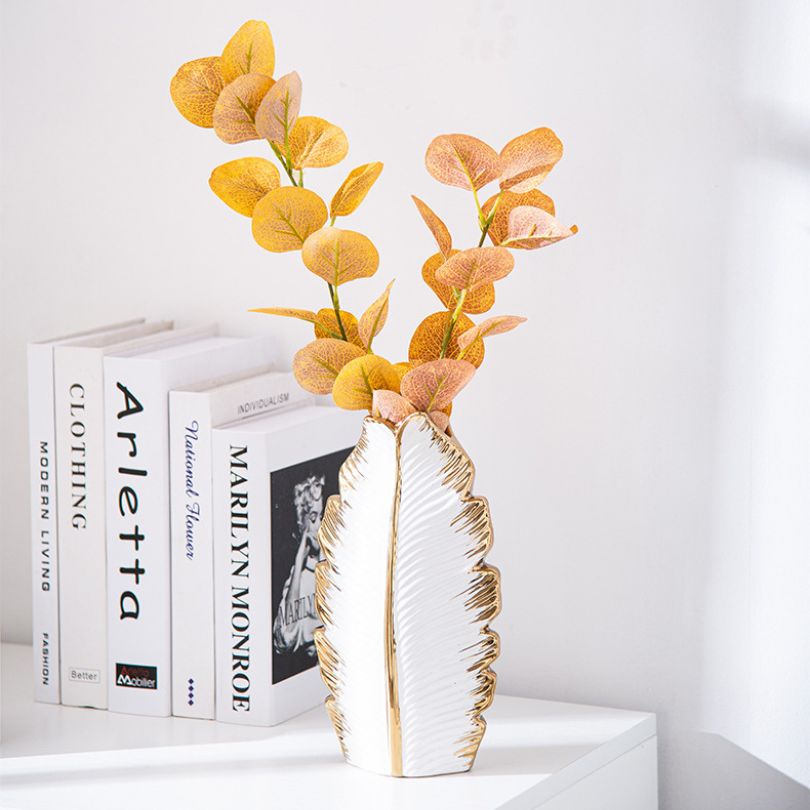 Elegant Nordic gold pleated leaf ceramic vase set displayed on a modern dining table.