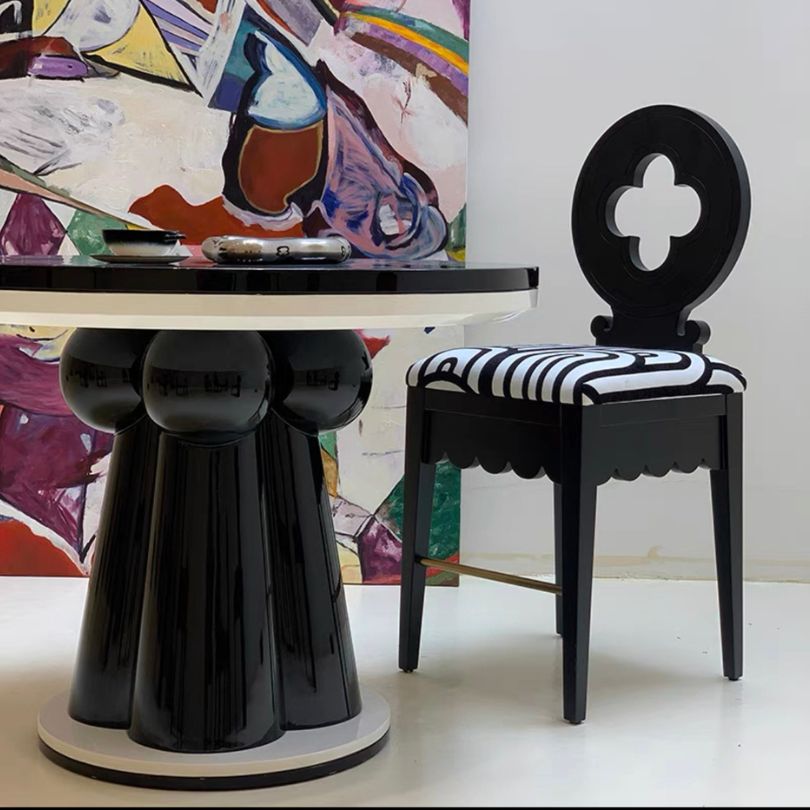Black Nordic Hollow Clovers chair with cushion set against a minimalist backdrop.