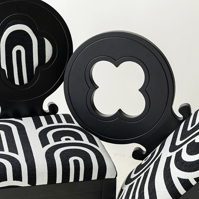 Black Nordic Hollow Clovers chair with cushion set against a minimalist backdrop.