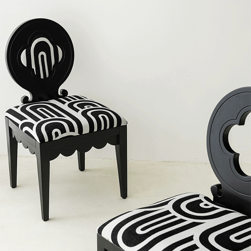 Black Nordic Hollow Clovers chair with cushion set against a minimalist backdrop.