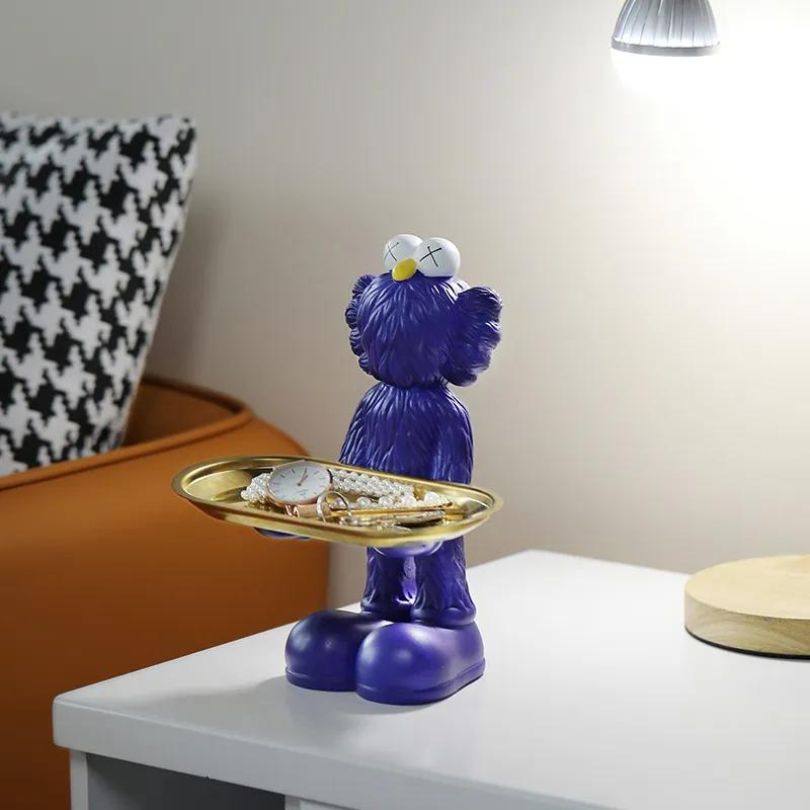 Nordic resin doll with storage tray displaying small trinkets in a stylish bedroom.