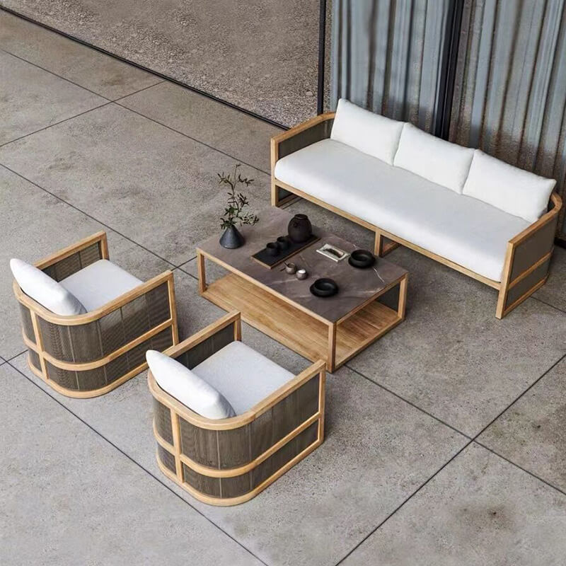 Side angle of the Nordic rattan set in a garden setting, illustrating its weatherproof fabric and stylish cushions.