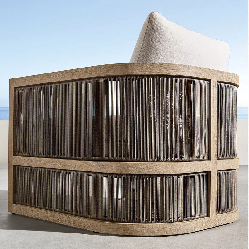 Side angle of the Nordic rattan set in a garden setting, illustrating its weatherproof fabric and stylish cushions.