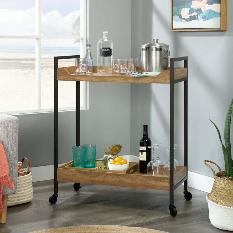 Nordic wood and metal bar cart showcasing wine glasses and plates from an angled view.