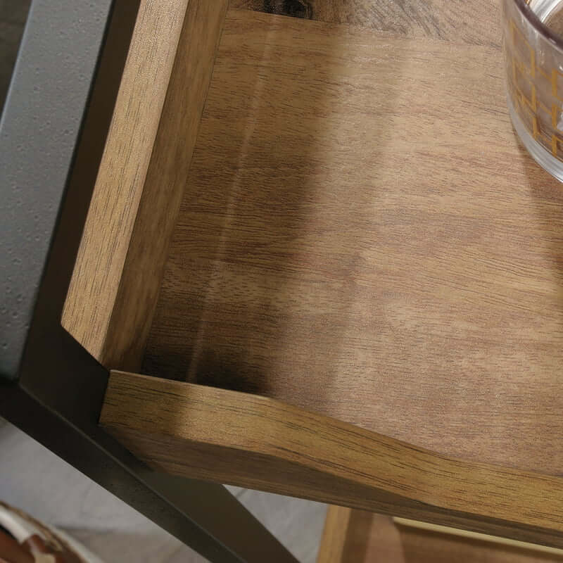 Nordic wood and metal bar cart showcasing wine glasses and plates from an angled view.