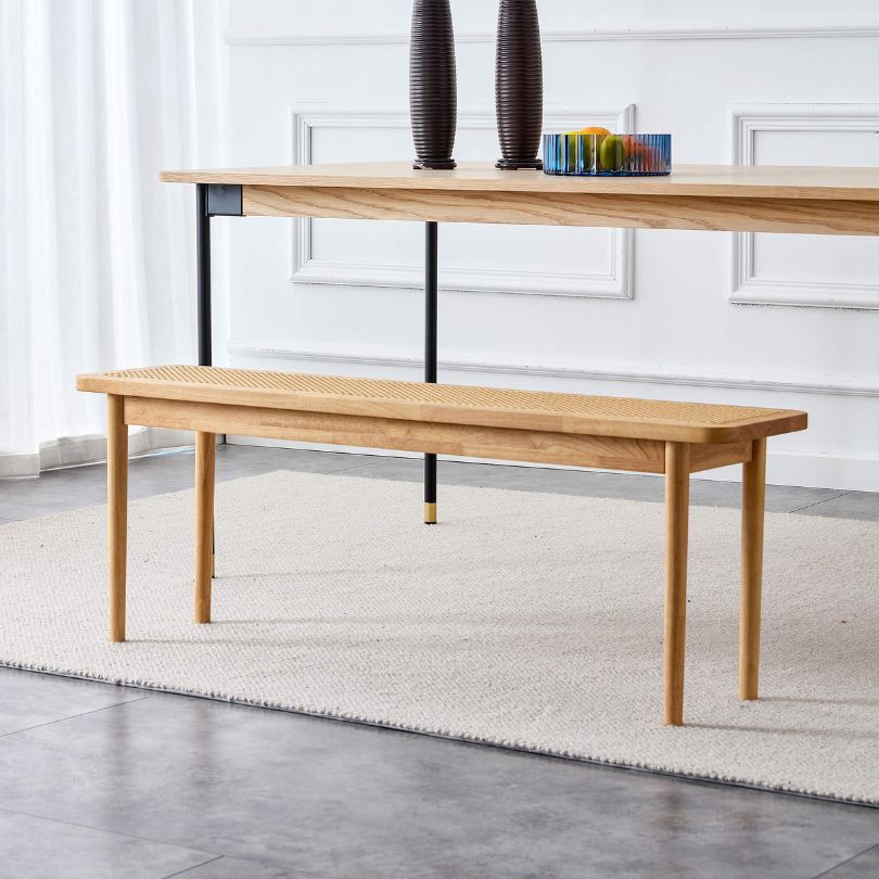 Front view of Nordic wood and rattan dining bench in a stylish dining room