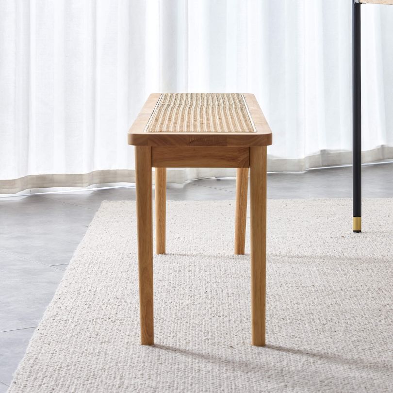 Front view of Nordic wood and rattan dining bench in a stylish dining room