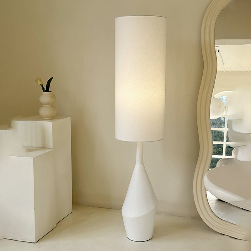 A side view of the Nordic Elegance Cream LED Floor Lamp illuminating a cozy reading nook.