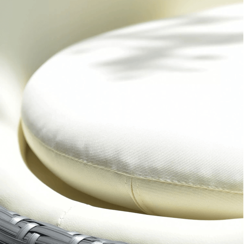 Close-up view of luxury rattan swing rocking chair on a patio with a cozy cushion