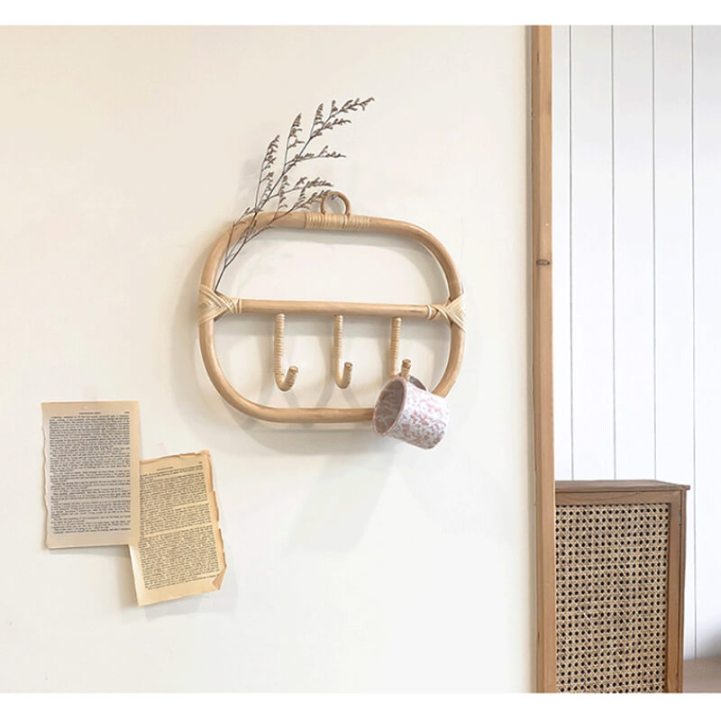 Close-up of the rattan coat hanger showcasing its natural weave and hooks.