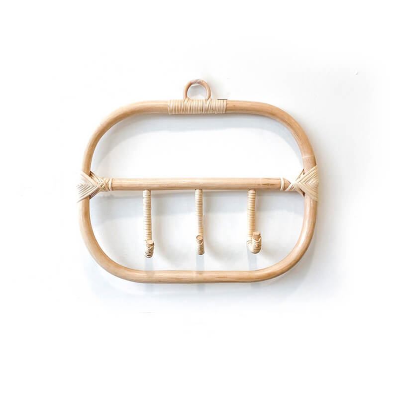 Close-up of the rattan coat hanger showcasing its natural weave and hooks.