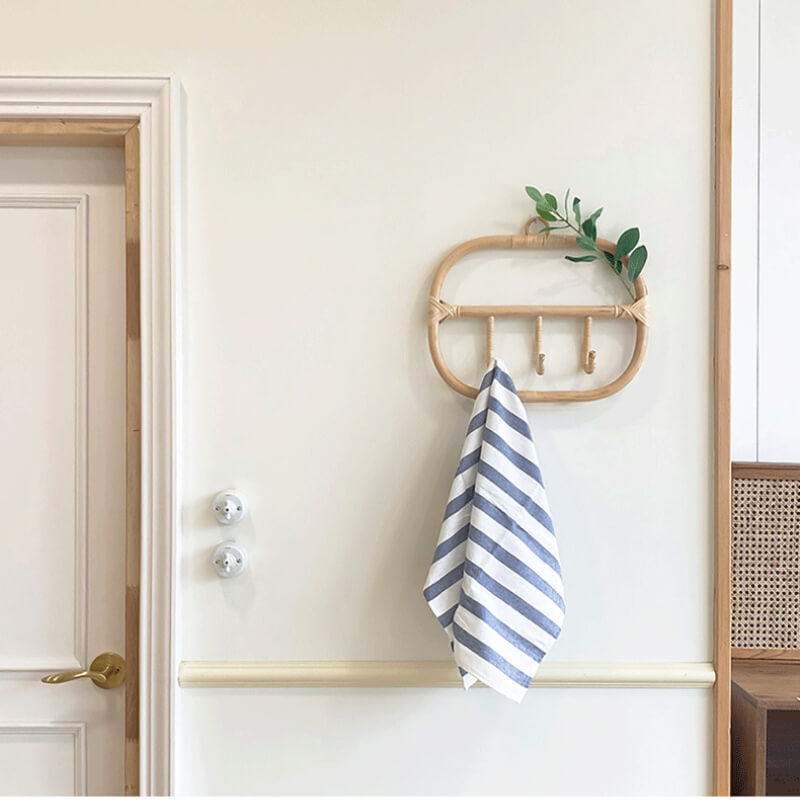 Rattan coat hanger in a cozy entryway, displaying coats and bags elegantly.