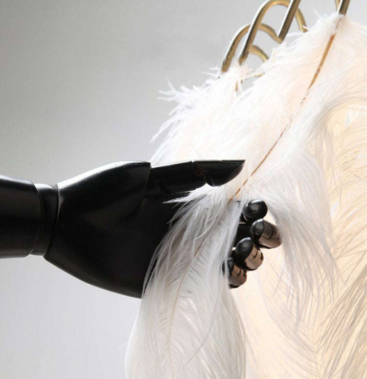 A stylish view of the elegant ostrich feather LED pendant light illuminating a cozy bedroom.