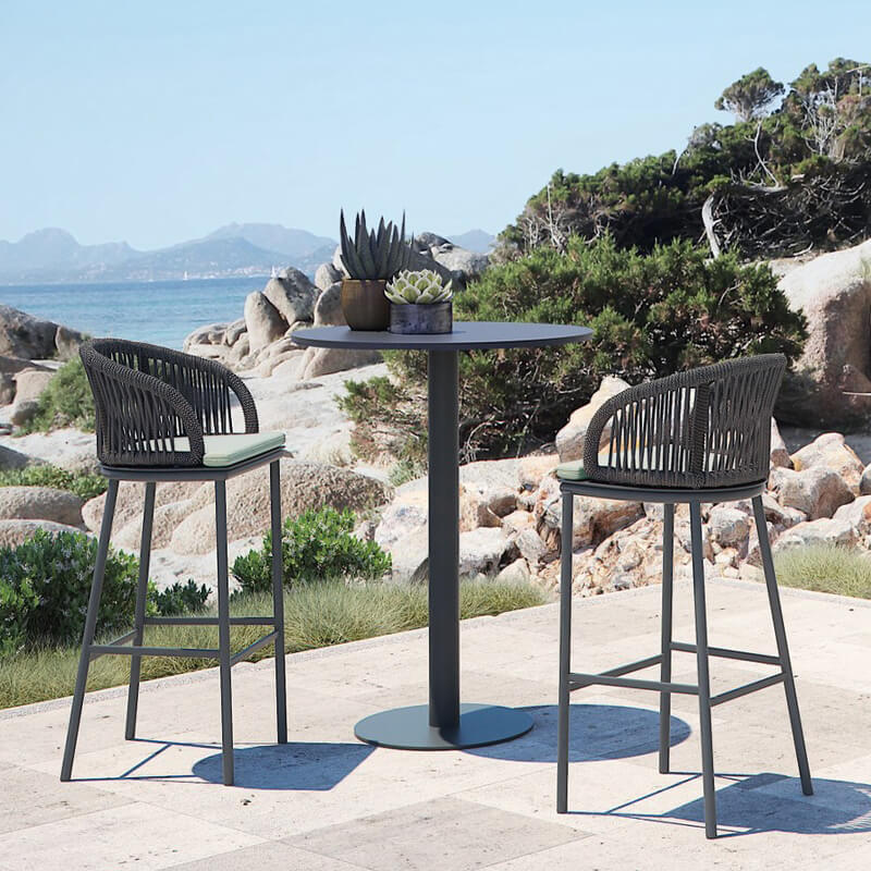 Elegant rattan high bar table set with aluminum legs in outdoor setting.