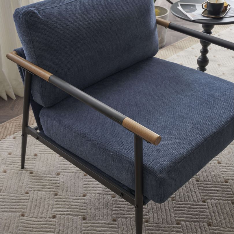 Front view of the vintage blue chenille armchair showcasing its soft padding and sleek black metal frame.