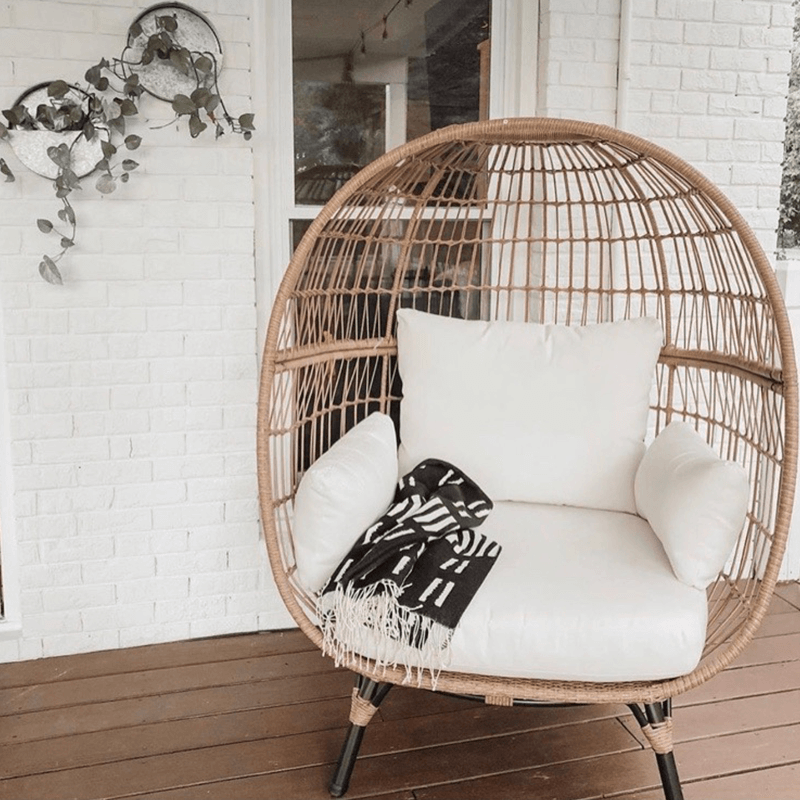 Side view of the Retro Ventura Outdoor Egg Chair with cushions in a sunny patio.