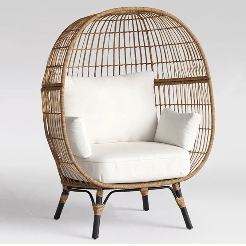 Natural setting featuring the Retro Ventura Wicker Patio Chair surrounded by greenery.
