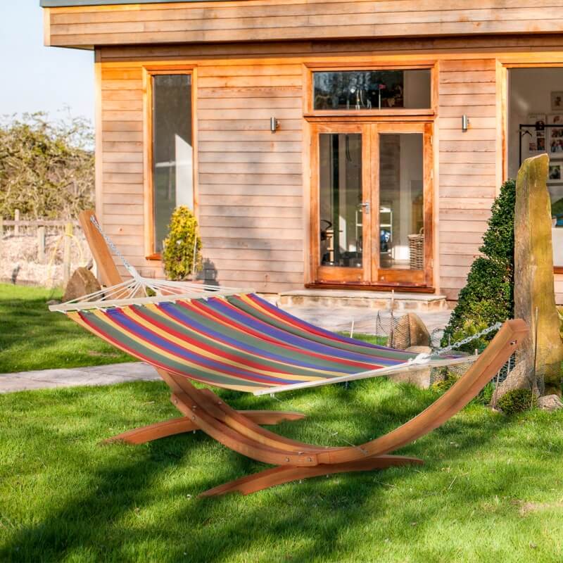 Vintage wooden hammock with stand in a serene garden setting, showcasing its elegant design.