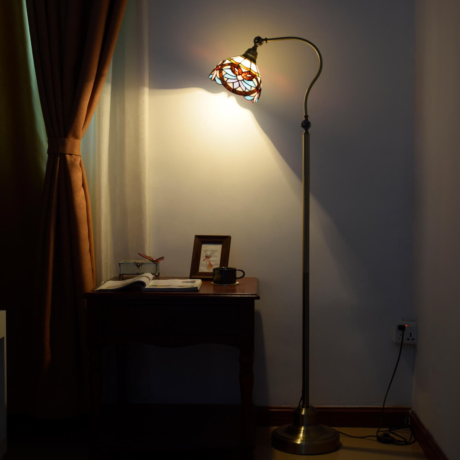 Close-up of the vintage Tiffany floor lamp illuminating a cozy reading nook.