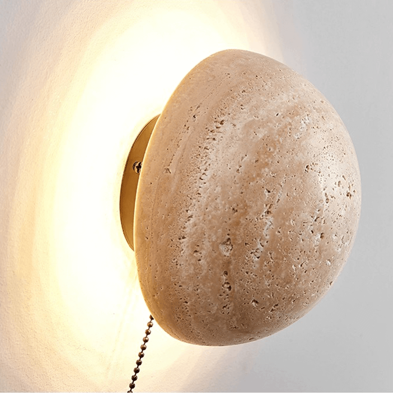 Close-up view of the travertine stone texture of the LED wall light, highlighting its unique character.