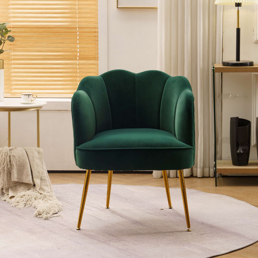 Side view of the dark green velvet accent chair showcasing its gold legs.