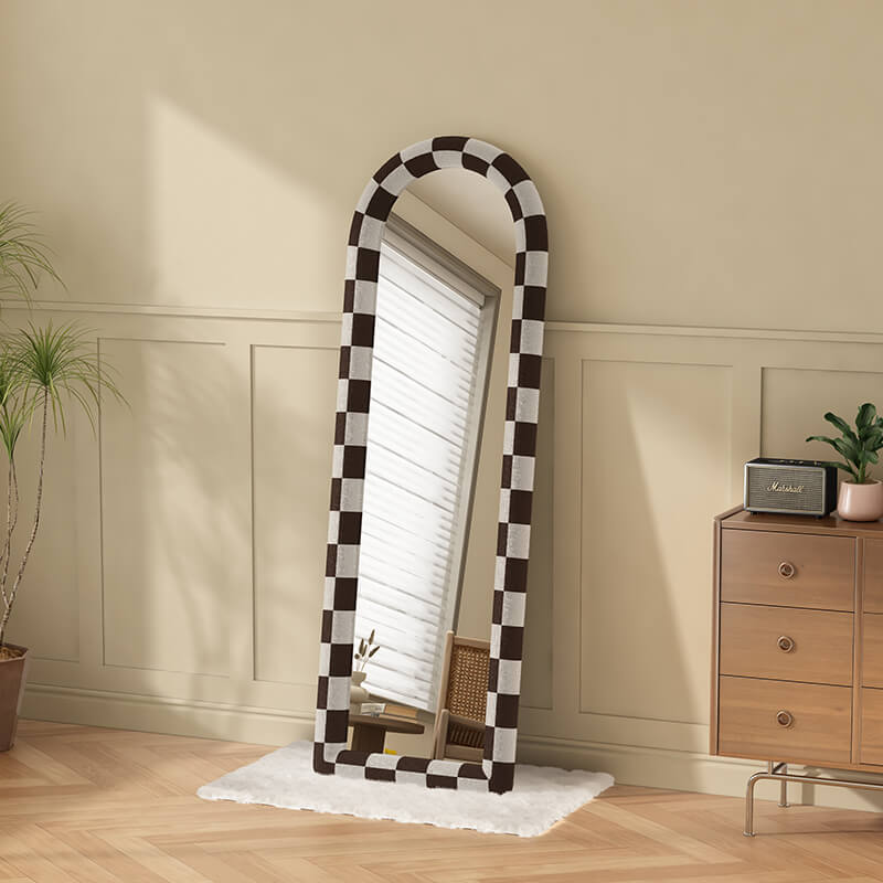 Side angle of the floor mirror reflecting a bright living space, highlighting its large size.