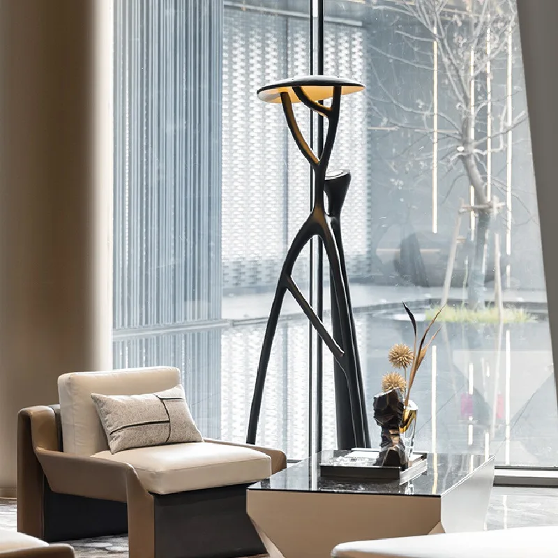 The black floor lamp illuminating a bedroom, creating a warm and inviting atmosphere.