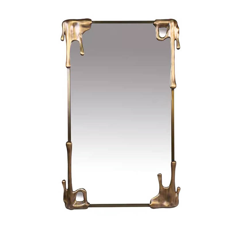 The vintage bronze frame mirror reflecting natural light, enhancing the rooms decor.