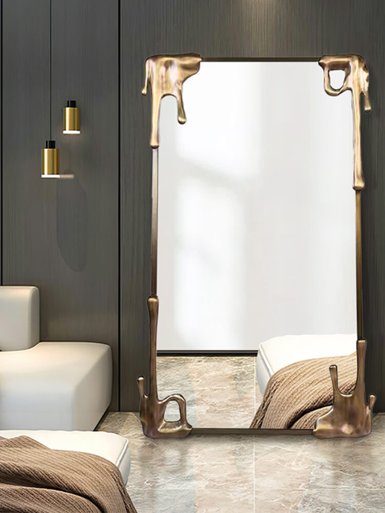 The vintage bronze frame mirror reflecting natural light, enhancing the rooms decor.