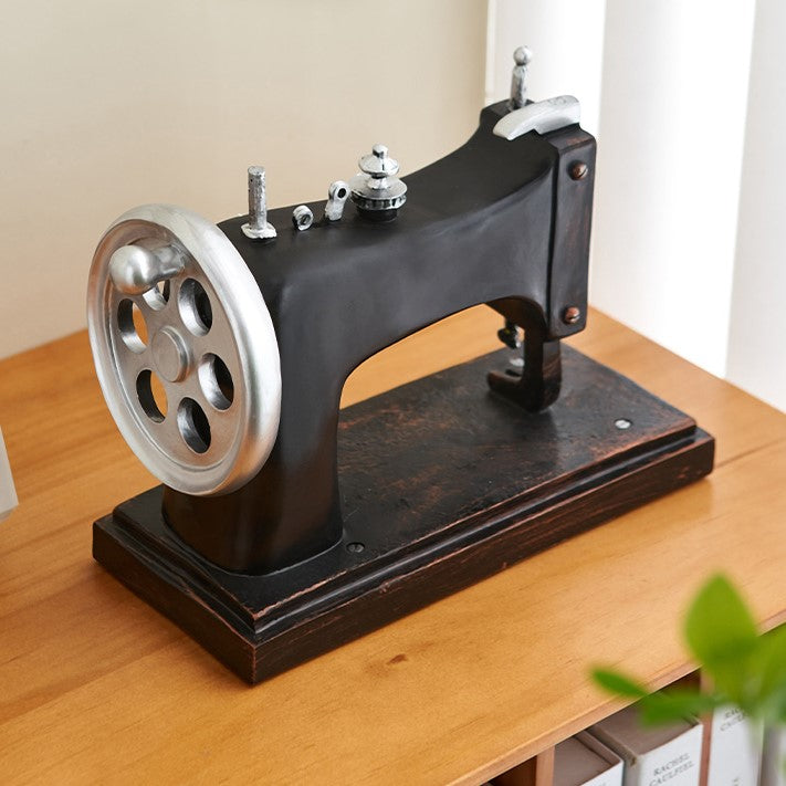 Side view of charming vintage resin sewing machine decor showcasing intricate details.