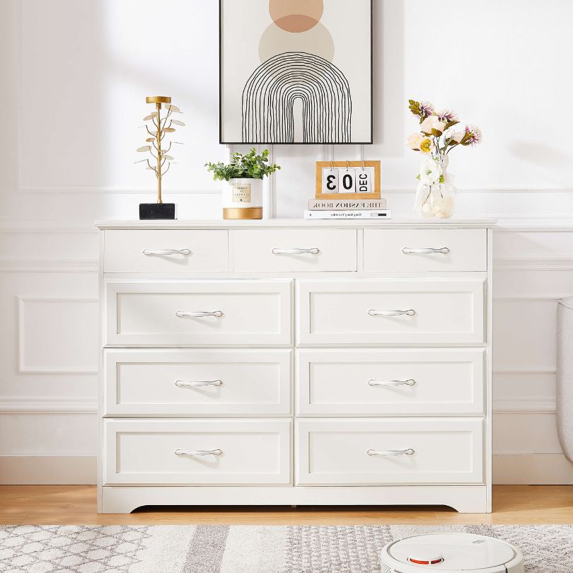 Front angle of white dresser showcasing 9 spacious drawers and antique handles