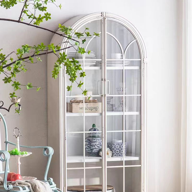 Side view of white arched bookcase placed in a home office setting with books and plants