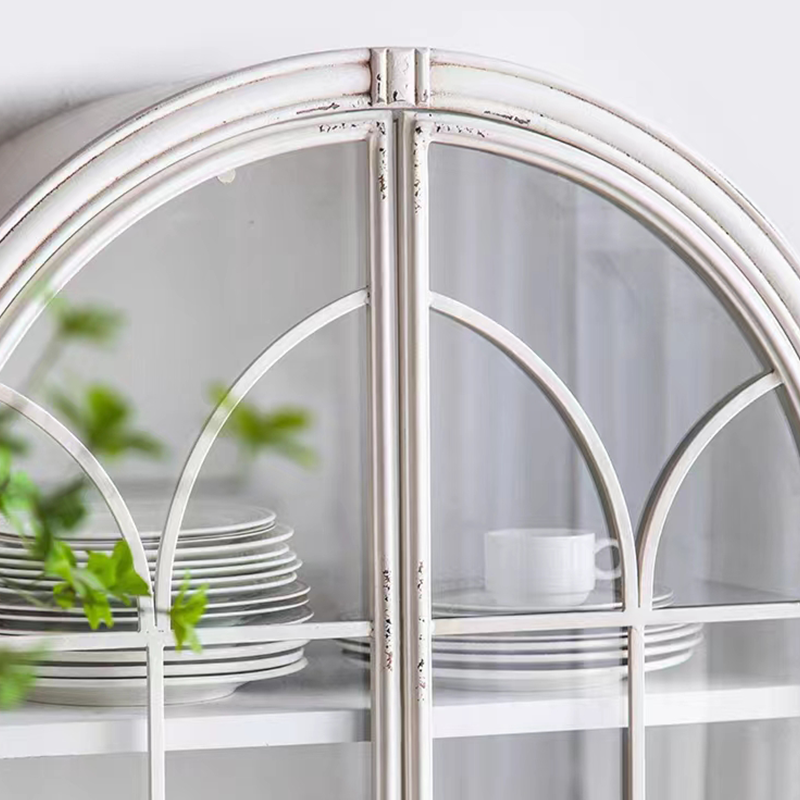 Side view of white arched bookcase placed in a home office setting with books and plants