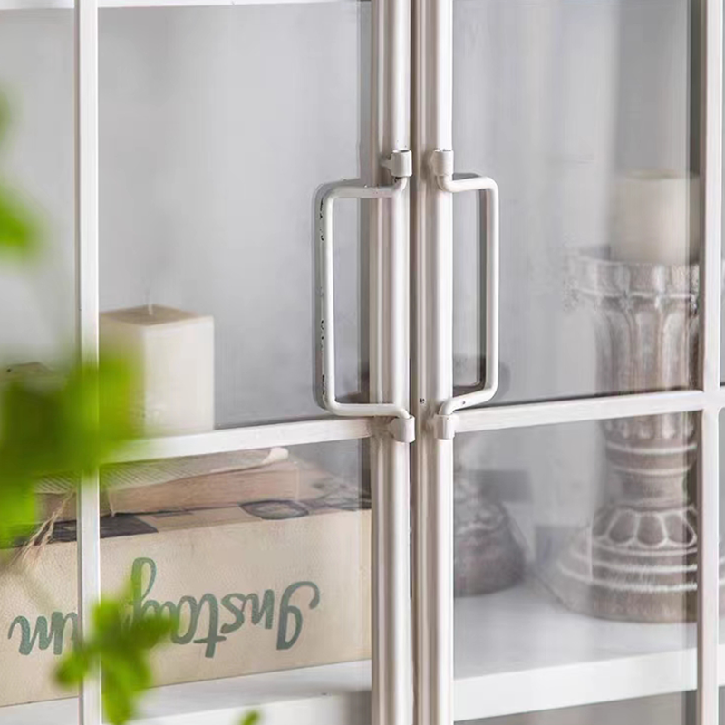 Front-facing image of white bookshelf with arched top and glass doors showcasing decor items
