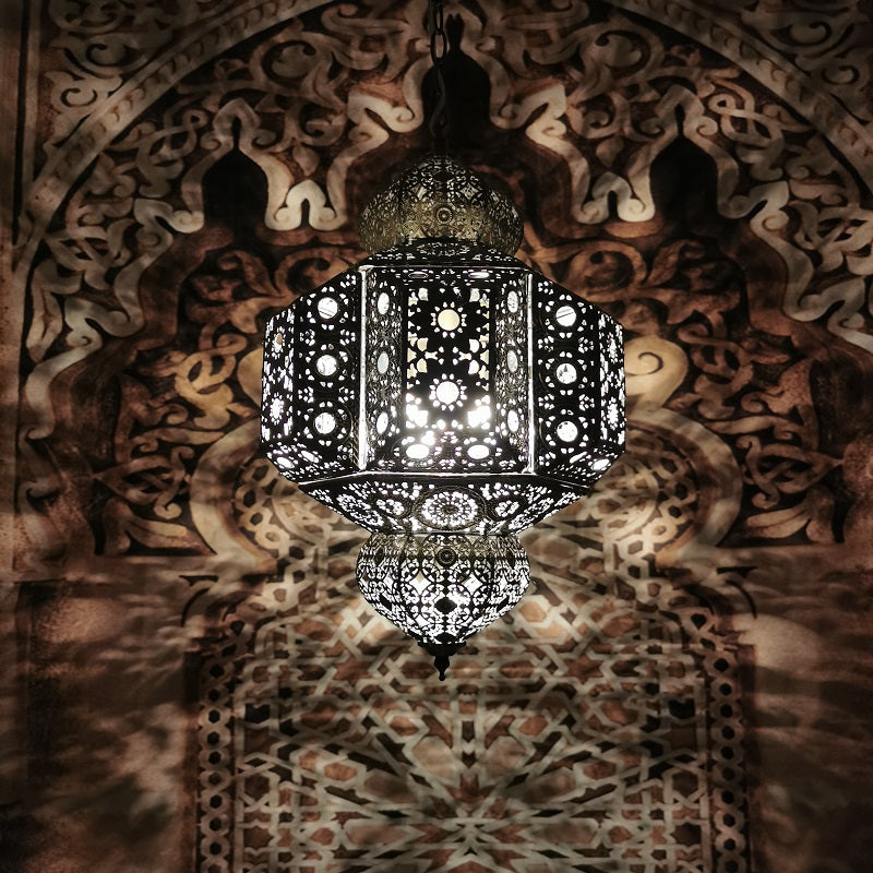 Moroccan pendant light illuminating a cozy bedroom, highlighting its unique design.