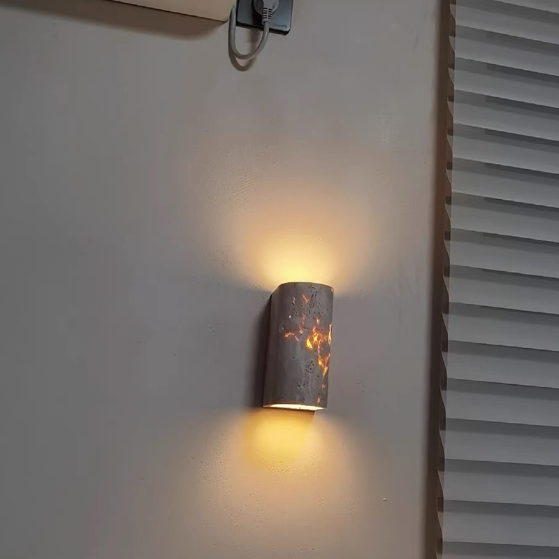 The elegant wall sconce lit up in a cozy living room setting, adding a touch of sophistication to the ambiance.