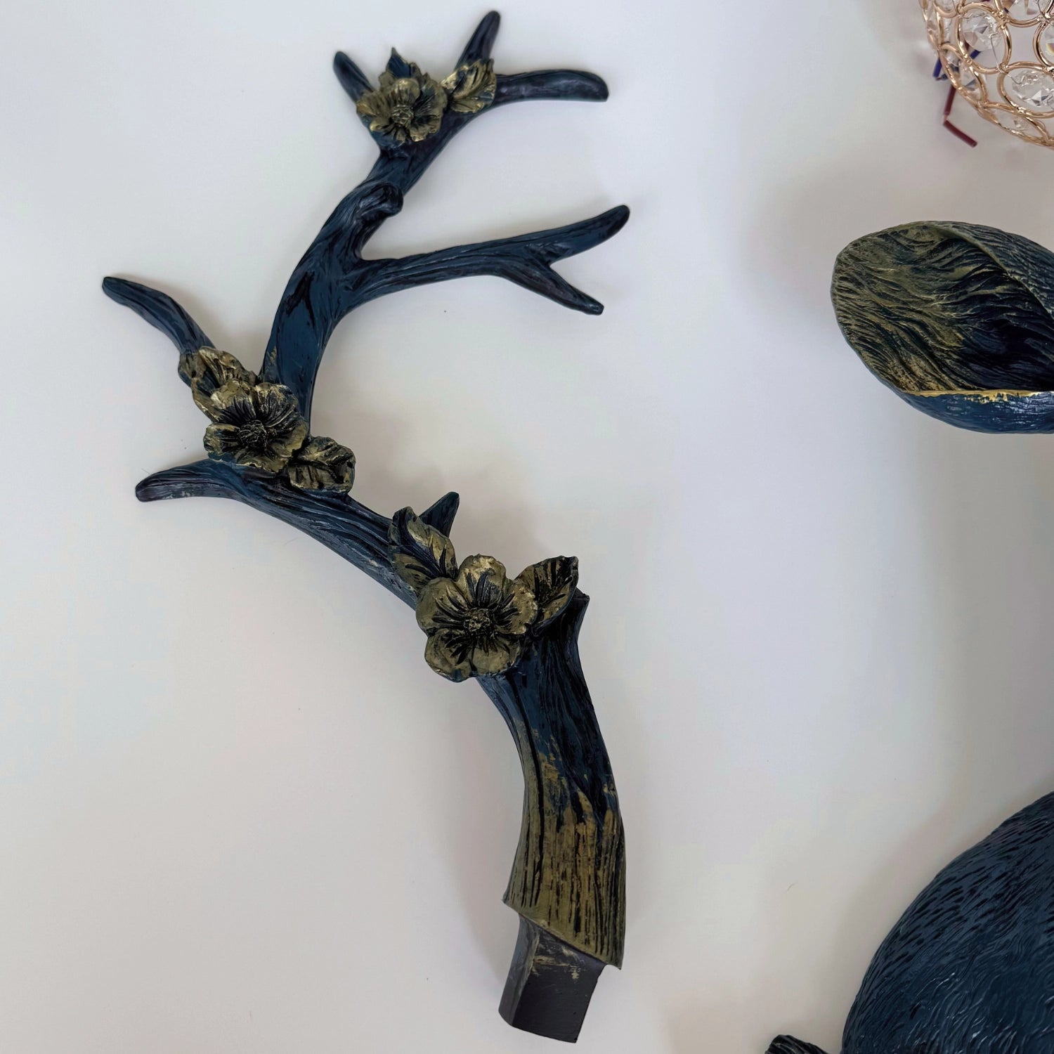 Wall-mounted LED floral deer head lamp glowing softly in rustic entryway decor.