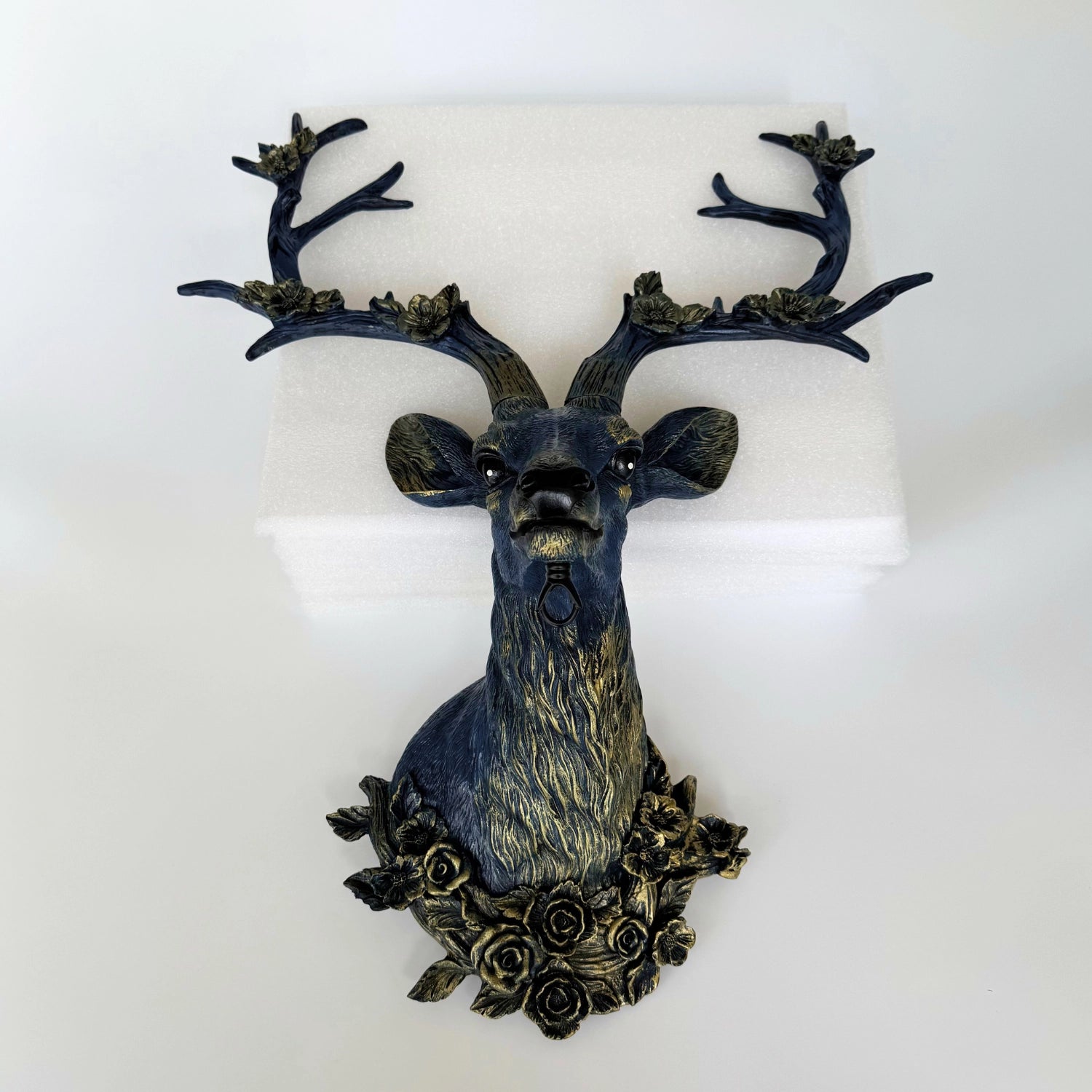 Front view of the deer wall sconce in white finish with floral antlers mounted in a cottagecore bedroom.