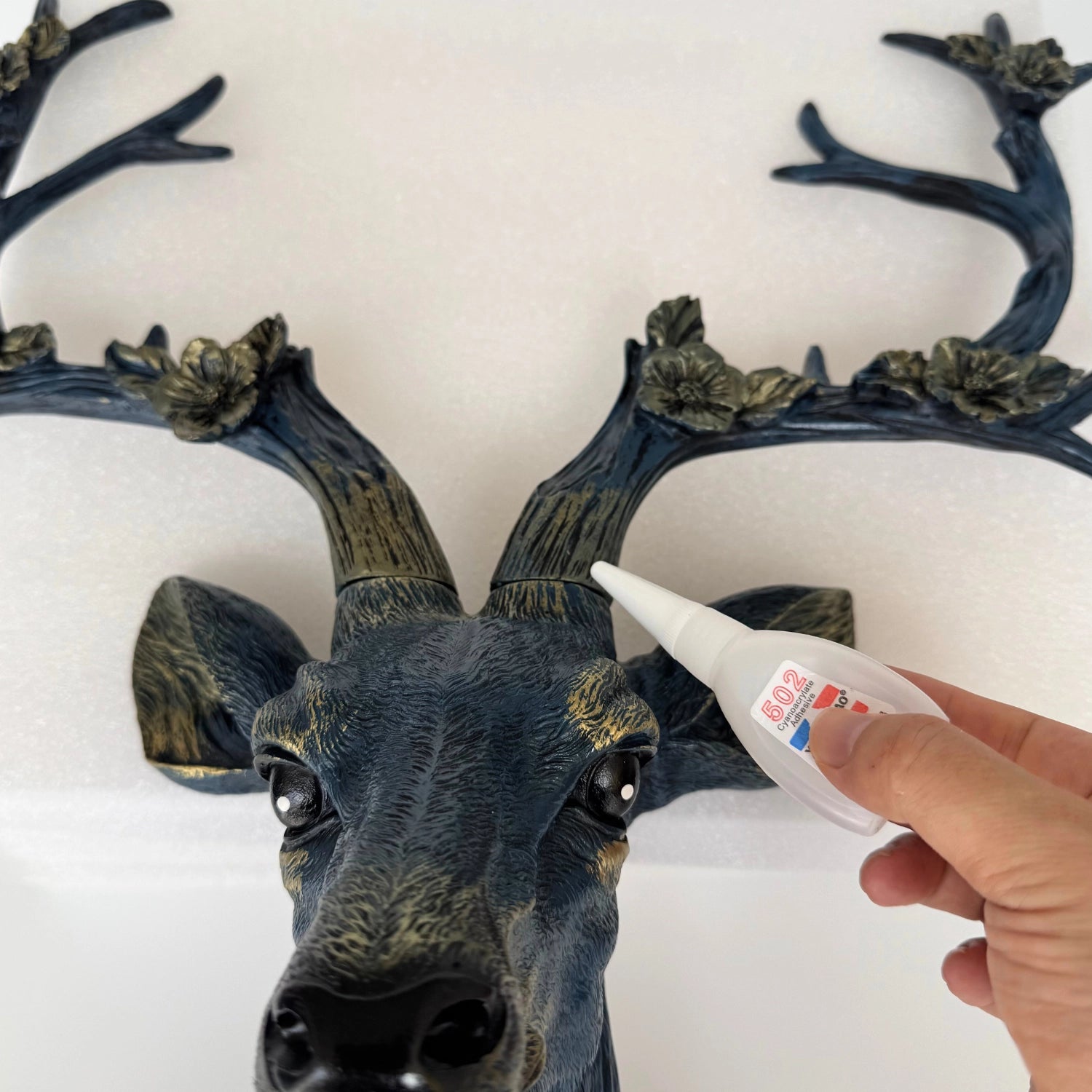 Close-up side angle of the antler light fixture in blue finish, showing sculpted fur details and petal accents.