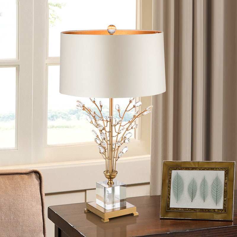 Modern crystal lamp in a cozy living room corner, with a soft glow from the fabric shade enhancing the contemporary décor.