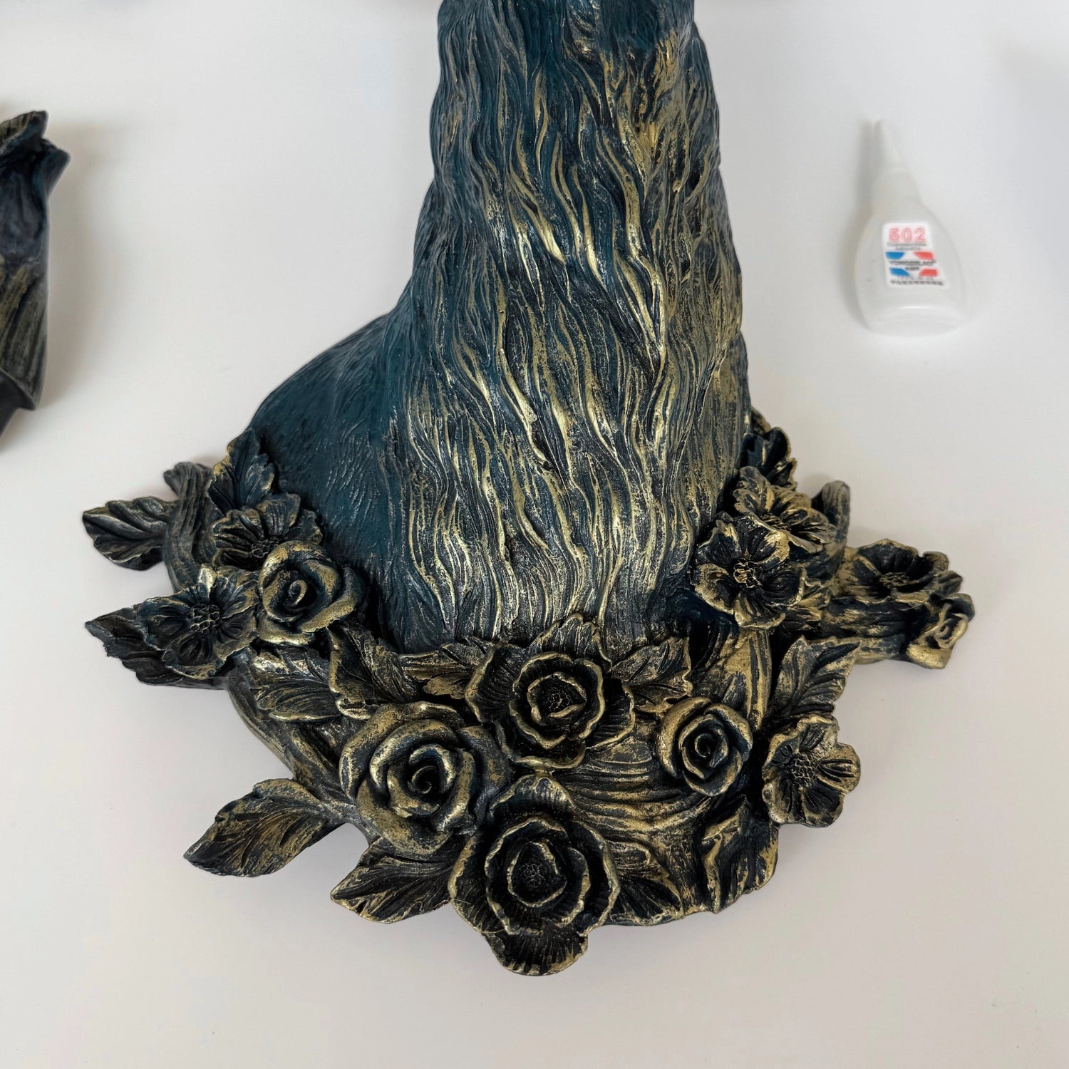 Close-up side angle of the antler light fixture in blue finish, showing sculpted fur details and petal accents.