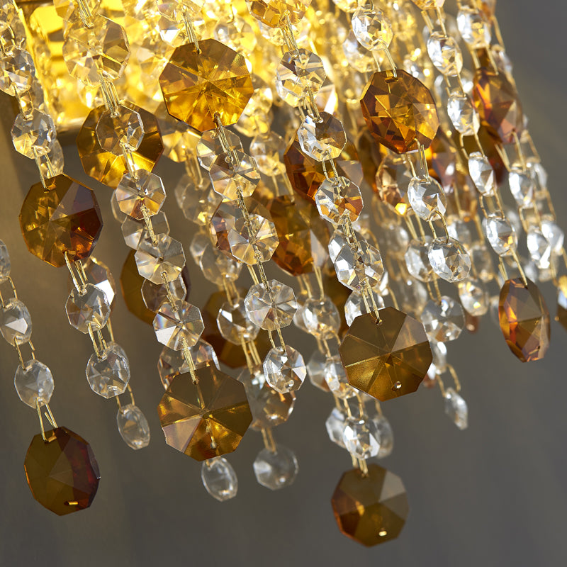 Elegant gold crystal teardrop wall sconce showcasing its luxurious design in a modern dining room.