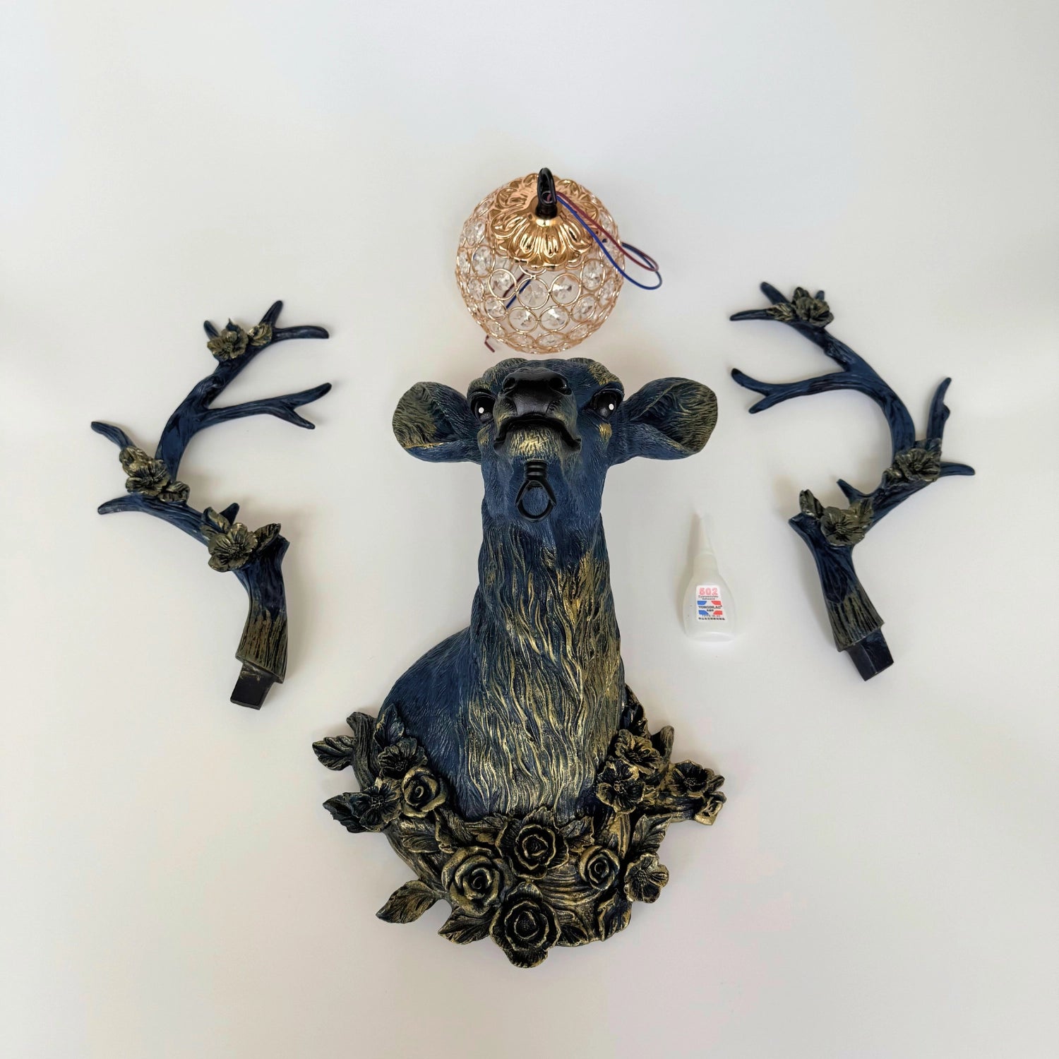 Wall-mounted LED floral deer head lamp glowing softly in rustic entryway decor.