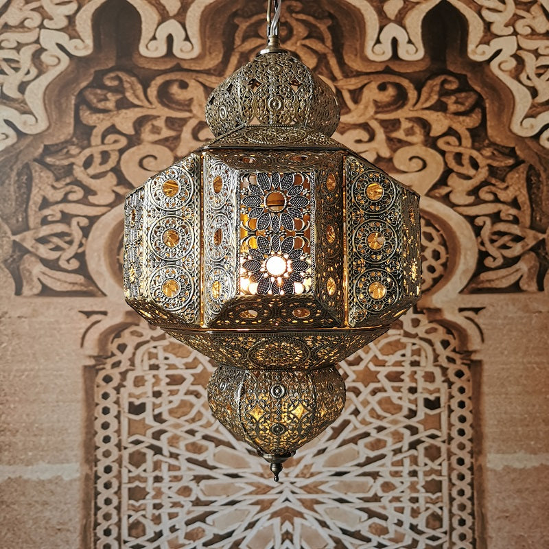 Moroccan pendant light illuminating a cozy bedroom, highlighting its unique design.