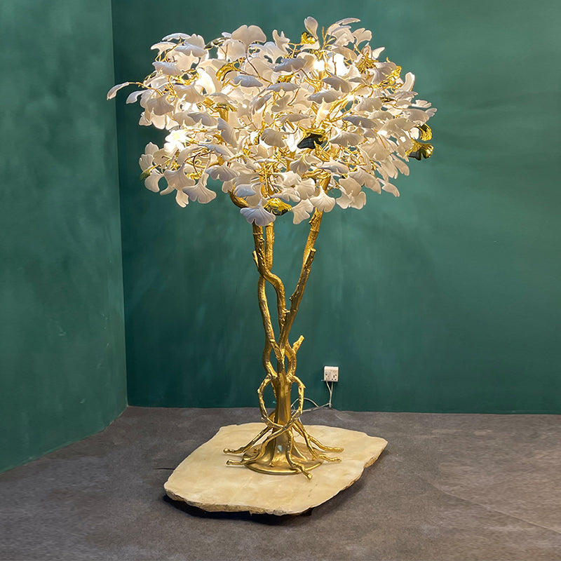Ginkgo tree floor lamp next to a comfortable reading chair, creating an inviting atmosphere.