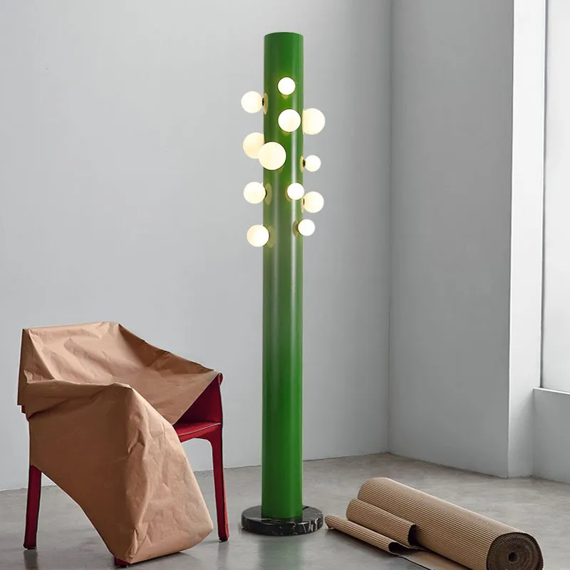 Elegant green cylinder glass floor lamp showcasing its intricate design and opal glass diffusers.