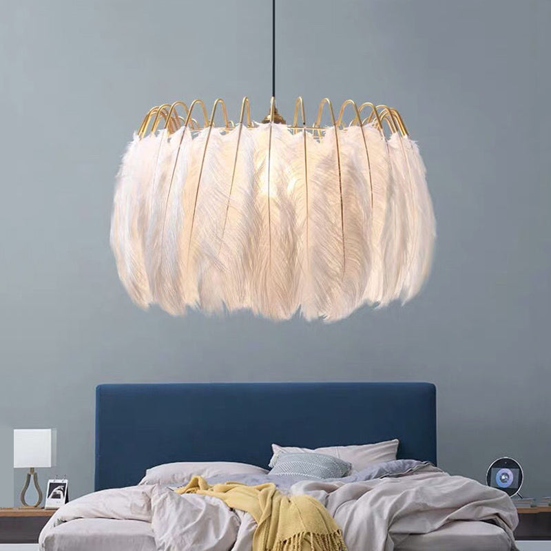 The elegant ostrich feather LED pendant light hanging in a modern dining room.