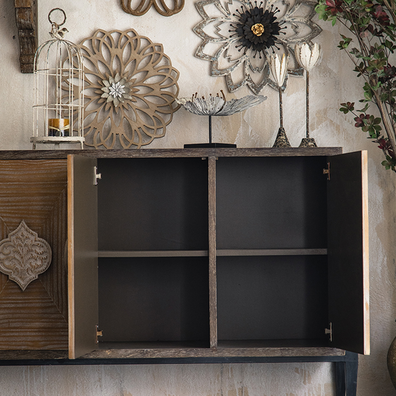 Close-up view of the rustic cabinets intricate carvings and distressed finish.
